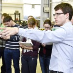 IKT-Wissenschaftler vor Studenten, zeigt Prüfeinrichtungen