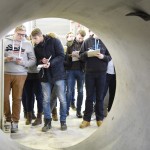 Blick aus Betonrohr auf Studenten mit Notizblöcken