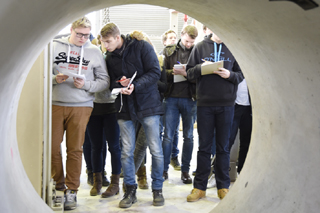 Blick aus Betonrohr auf Studenten mit Notizblöcken