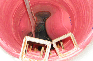 rosafarbene Kunststoffbeschichtung von Abwasserschacht mit extrem großen Blasen