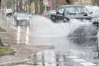 Auto fährt durch überflutete Straße