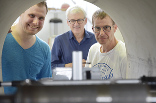 Bretz, Thépot und Meynier blicken in das Rohr, in dem das MAC steht.