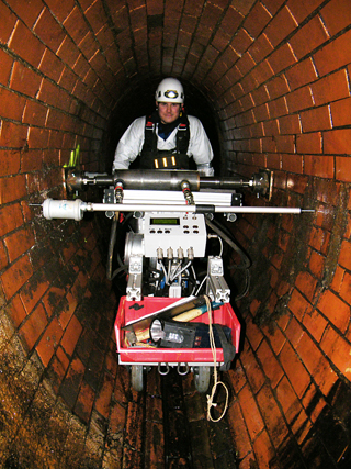 IKT employee using the MAC measurement system in a man-entry egg-shaped masonry sewer