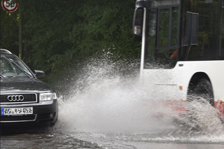 Auto und Bus auf überfluteter Straße