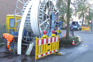 Baustelle mit Absperrung und große Haspel mit aufgerolltem Schlauchliner