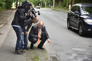 Roland Waniek und WDR-Kamerateam an einem Straßeneinlauf