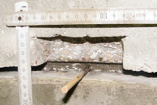 Schachtringfuge mit einem Bohrloch und einem herausgebrochenen Stück Beton
