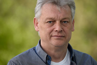 Portrait eines Manns mit grauen Haaren und blauem Hemd