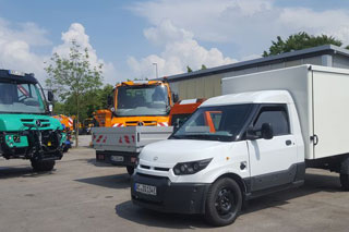 grüner Unimog, orangener Unimog, weißer Elektro-Transporter