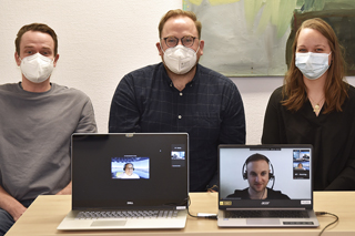 Gruppenbild mit drei Personen und Laptops