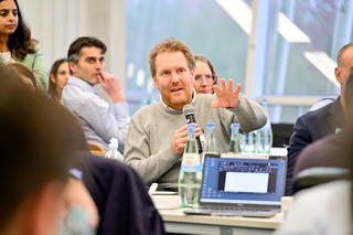 Teilnehmer einer IKT-Veranstaltung im fachlichen Austausch in einer Diskussionsrunde